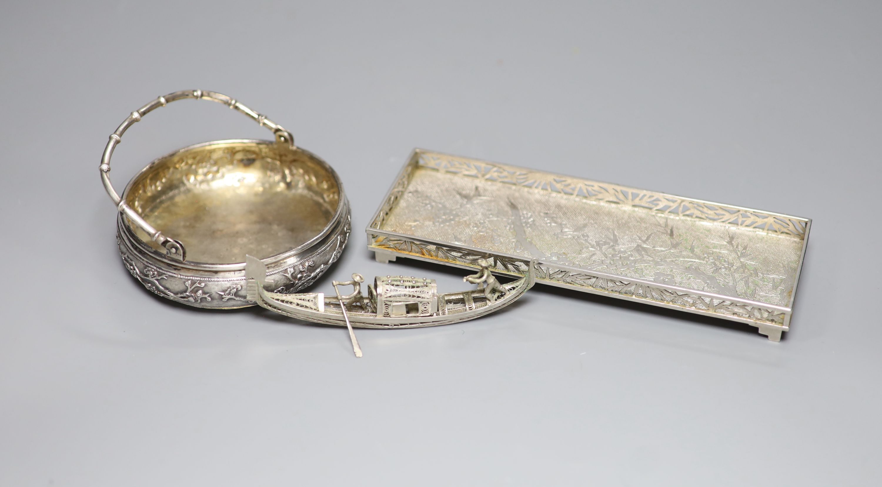An early 20th century Chinese Export white metal rectangular tray, maker LH, 18.8cm, together with a similar bonbon basket and a small filigree junk